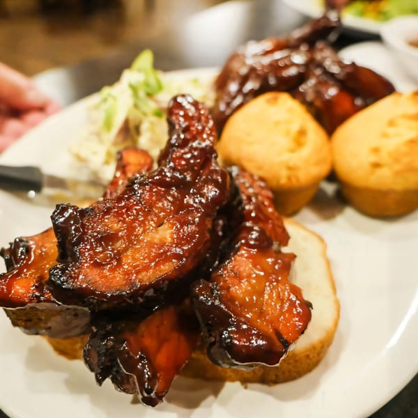 A plate of JP's Family Restaurant's BBQ ribs, coleslaw, and cornbread muffins.